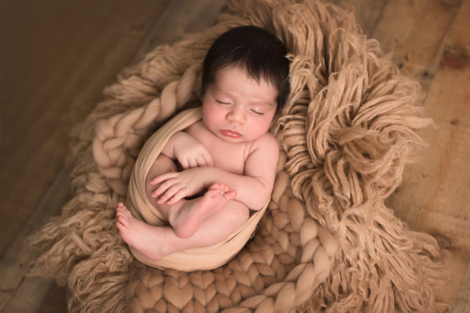 Newborn boy laying in brown wrap and textures taken by DMV photographer Sarah Botta Photography at Woodbridge VA studio