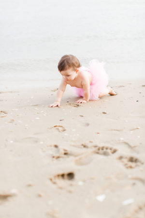Virginia milestone photographer Sarah Botta Photography photographs girl crawling on beach in pink tutu in New Jersey