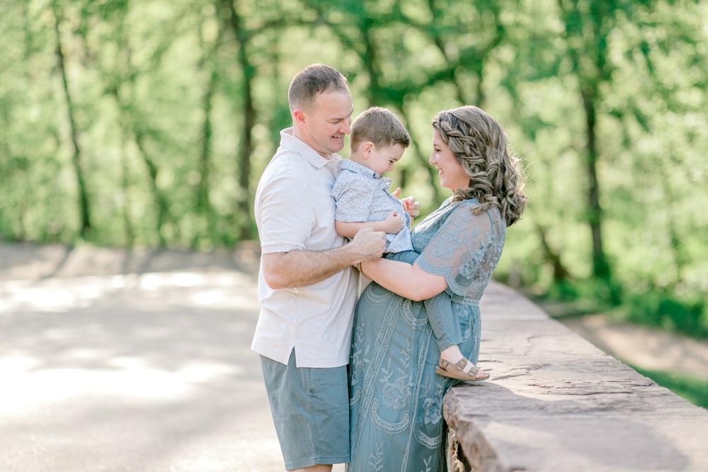 Maternity session outdoors with Sarah Botta Photography. Family image looking at camera and young boy surrounded by trees.